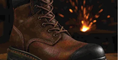 Bota de trabajo de cuero diseñada para soldadores, sobre superficie metálica con chispas de fondo, mostrando su diseño resistente al calor y la suela reforzada.