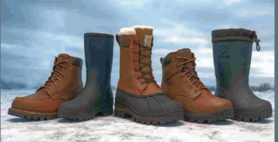Cinco botas de trabajo para invierno alineadas sobre nieve, mostrando distintos estilos y materiales como cuero, neopreno y goma, bajo un cielo nublado.